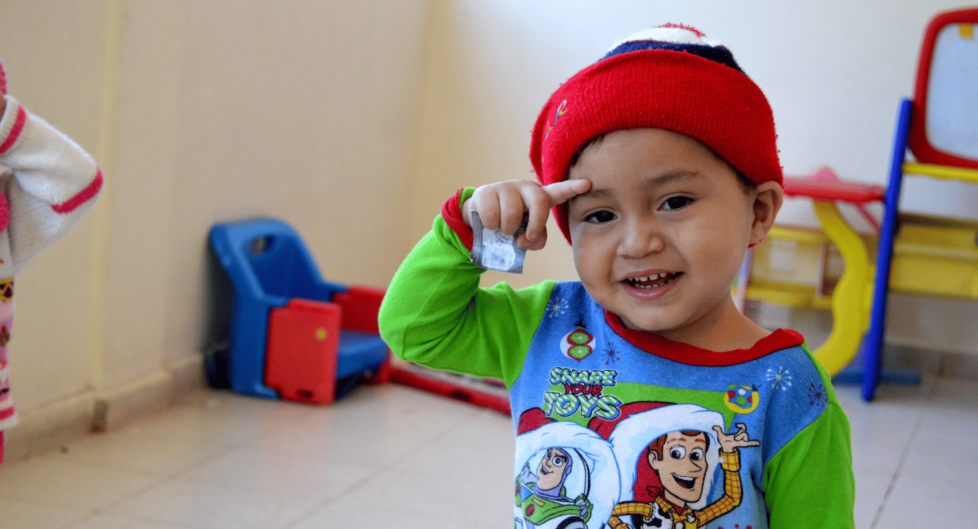 Ein Bub mit einer roten Haube freut sich auf den Besuch vom Kindergarten von NPH